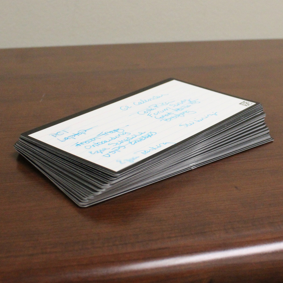 A stack of reusable, erasable index cards with handwritten notes on them.